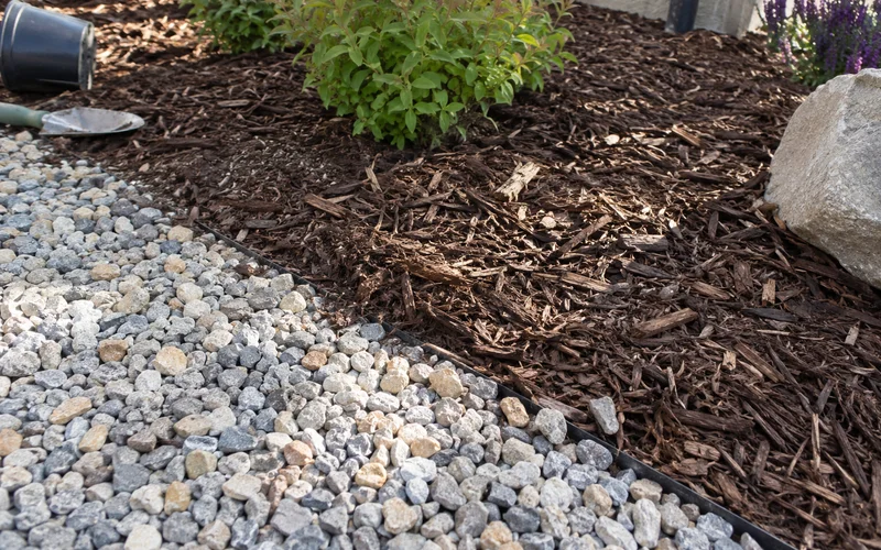 Close-up of decorative gravel meeting bark mulch in a Utah planting bed