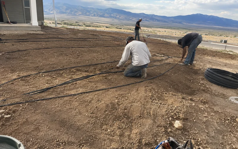 Crew laying irrigation lines in a freshly graded new-construction yard