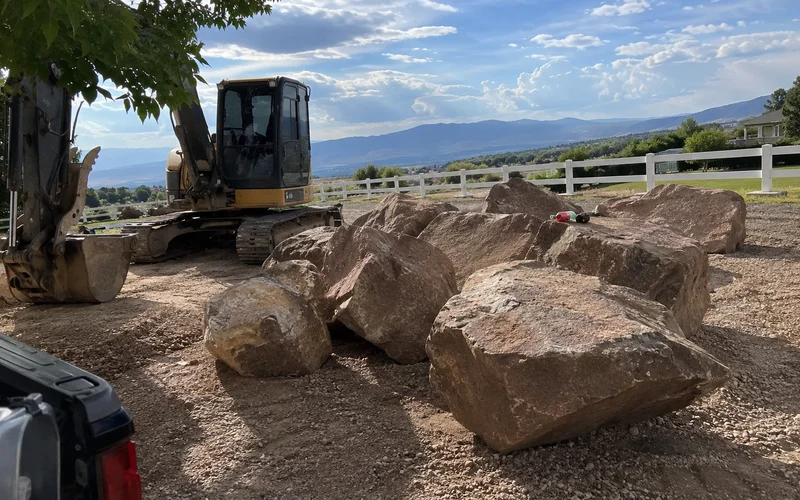 Fieldstone boulders staged on a rural Utah property ready for placement