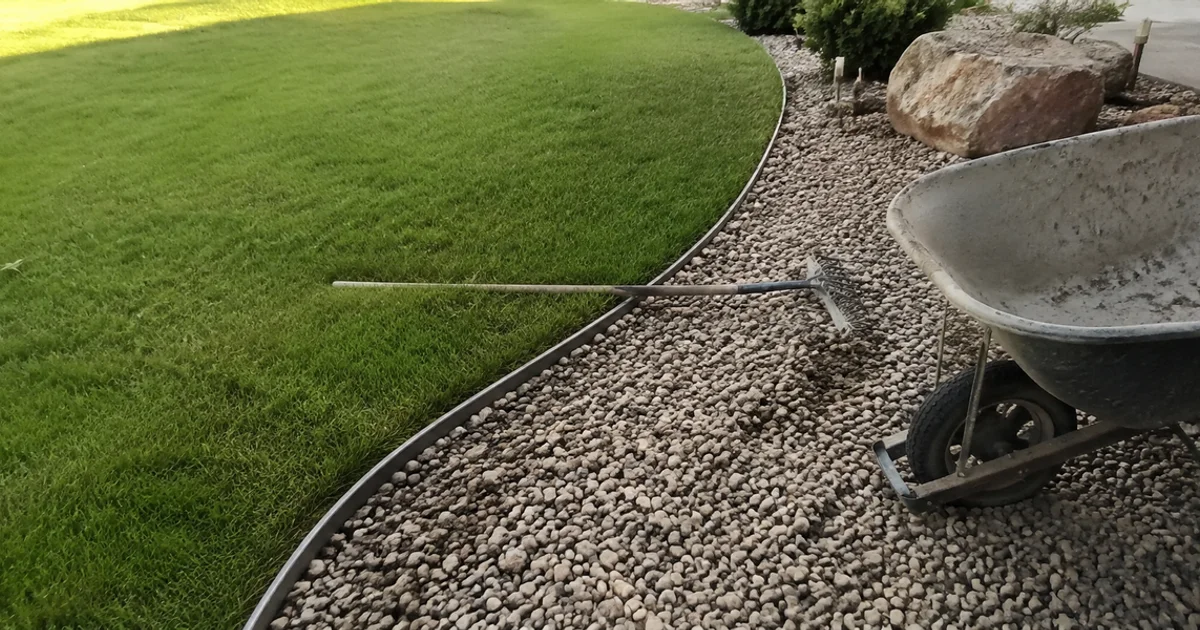 Clean steel edging separating a green lawn from a decorative gravel bed