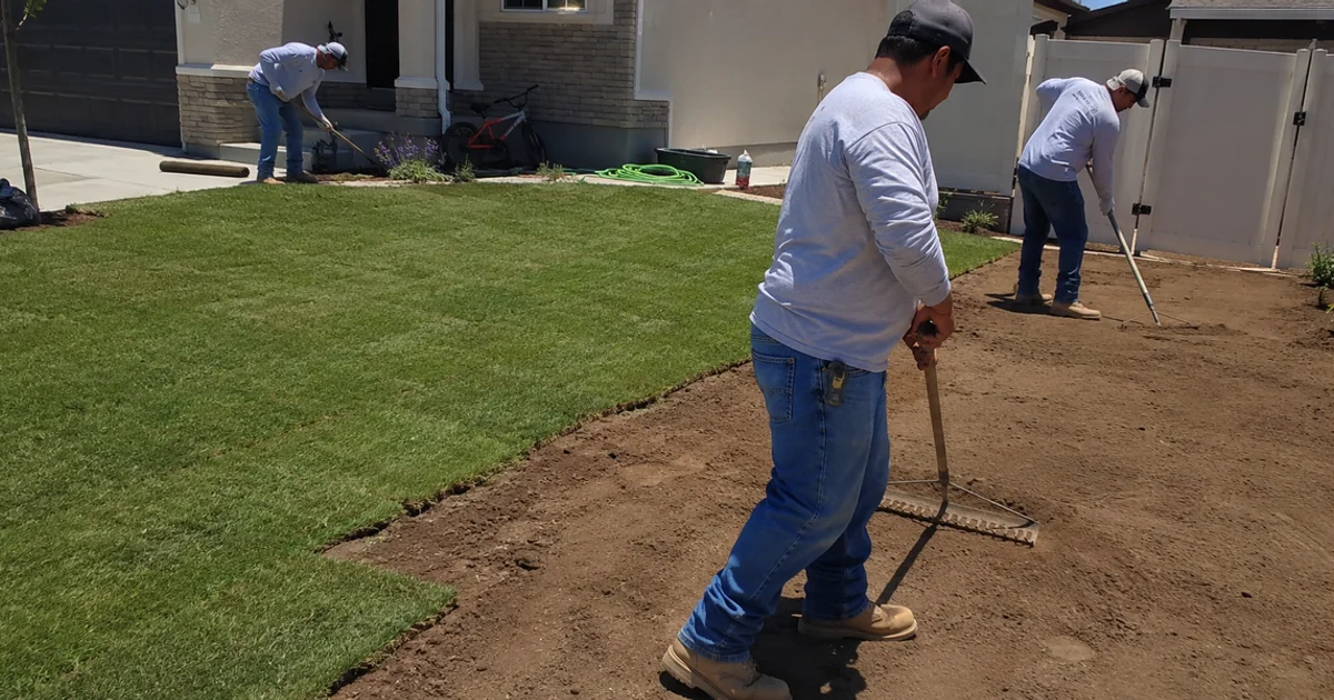 Landscaping crew working a new Utah yard install with half the lawn finished and half still bare soil
