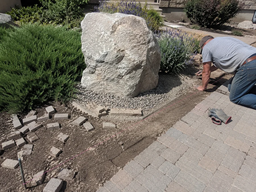 Decorative granite boulder accent set into a planted Utah landscape bed