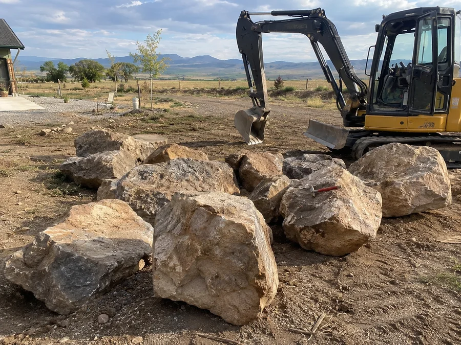 Fieldstone boulders staged on a rural Utah property ready for placement